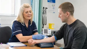 an addiction treatment nurse helping a male patient with his heroin detox